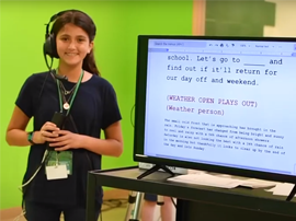 TV Production Student standing next to teleprompter